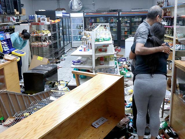 Yogi Dalal hugs his daughter Jigisha as his other daughter Kajal bows her head at the family store Aug. 10, 2020, after the family business was vandalized in Chicago. (AP Photo/Charles Rex Arbogast)
