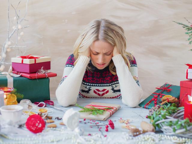 Stressed woman wrapping Christmas gifts