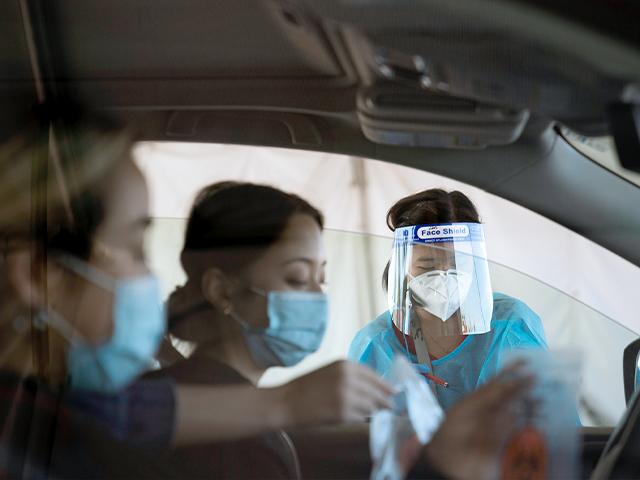 Medical assistant Linh Nguyen assists two women with COVID-19 testing at a testing site set up at the OC Fairgrounds in Costa Mesa, Calif., Nov. 16, 2020. (AP Photo/Jae C. Hong)