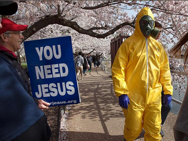 A 17-year-old wears a hazmat suit, gas mask, boots, and gloves as he walks under cherry blossom trees in full bloom along the tidal basin March 22, 2020, in Washington. (AP Photo/Jacquelyn Martin)