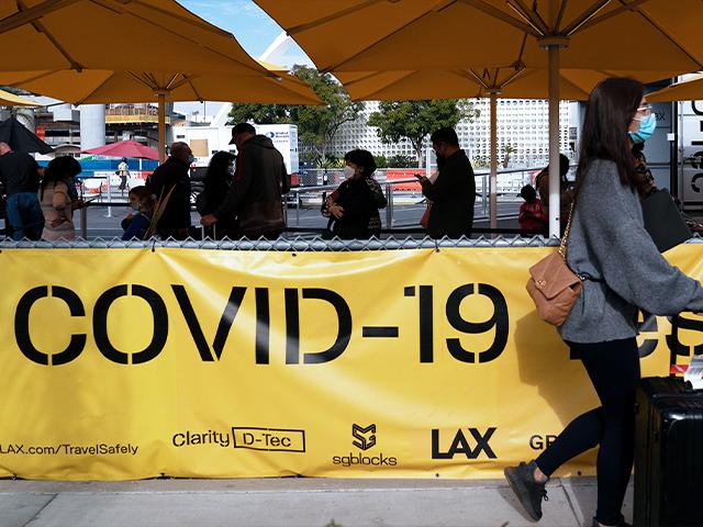 Travelers wait in line to get tested for COVID-19 at Los Angeles International Airport in Los Angeles, Monday, Dec. 20, 2021.