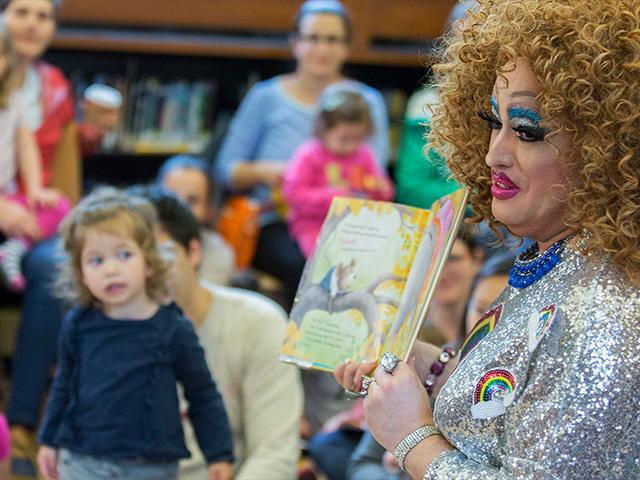 Drag queen story hours have been cropping up in community libraries in recent years like this one in 2017 in Brooklyn, N.Y.  Now a major health insurer has featured a drag queen event with kids in a TV commercial. (AP Photo)