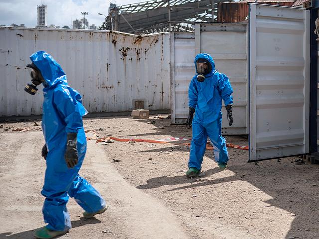 French emergency workers, part of a special unit working with chemicals, walk next to damaged containers near the site of last week&#039;s explosion, in the port of Beirut, Lebanon, Monday, Aug. 10, 2020. Associated Press