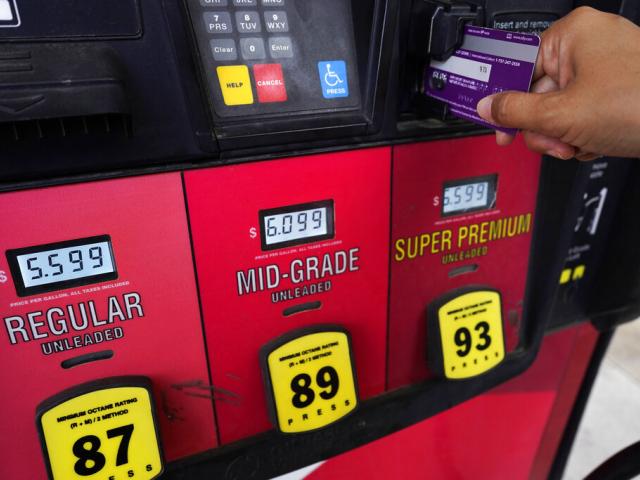 A customer pays at a gasoline pump in Rolling Meadow, Ill., June 30, 2022. (AP Photo/Nam Y. Huh)