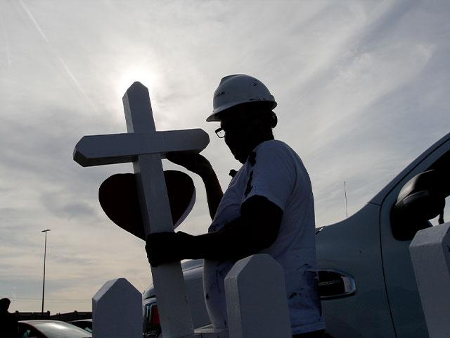 Greg Zanis prepares crosses to place in memory of victims at a makeshift memorial for victims of a mass shooting at a shopping complex Monday, Aug. 5, 2019, in El Paso, Texas. (AP Photo/John Locher)