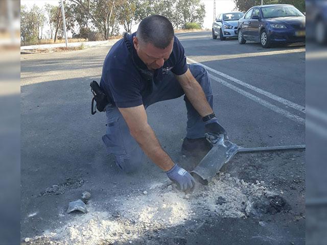 Police Officer Examines Spent Rocket, Photo, Israel Police Spokesman&#039;s Office
