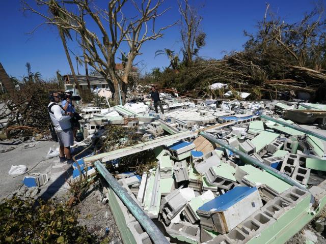 A TV news crew works in debris on Sanibel Island, in the aftermath of Hurricane Ian, Friday, Sept. 30, 2022, on Sanibel Island, Fla. (AP Photo/Steve Helber)