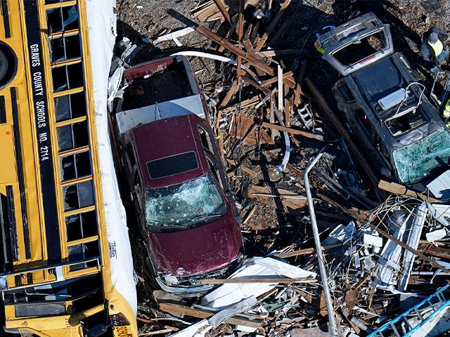 In this aerial photo, responders sift through debris near an overturned school bus in the aftermath of tornadoes that tore through the region, in Mayfield, Ky., Dec. 12, 2021. (AP Photo/Gerald Herbert)