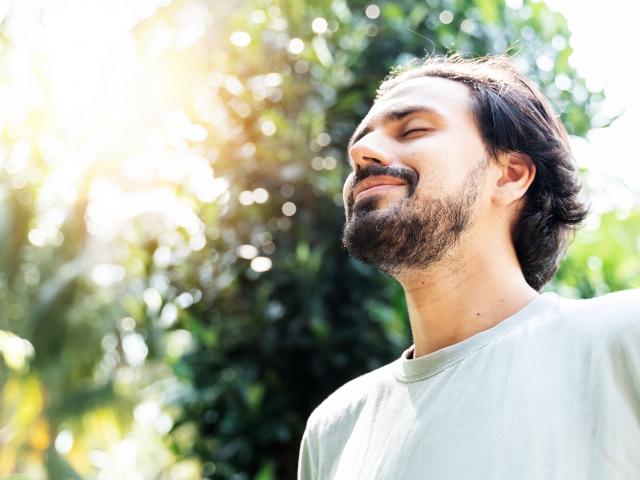 smiling man in sunlight forest