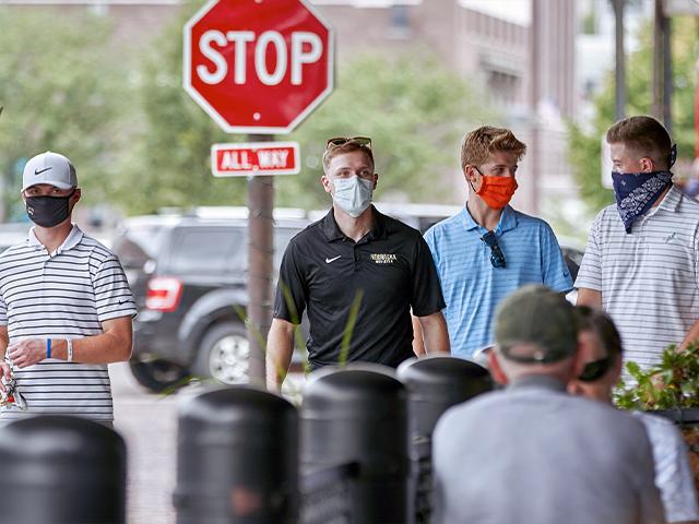 Pedestrians with face masks walk past diners in downtown Omaha, Neb., Aug. 7, 2020. (AP Photo/Nati Harnik)