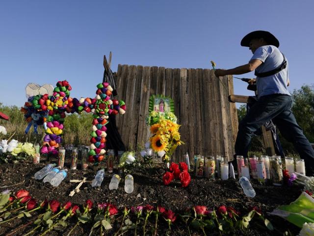 makeshift memorial at the site where officials found dozens of people dead in an abandoned semitrailer containing suspected migrants, Wednesday, June 29, 2022, in San Antonio. (AP Photo/Eric Gay)