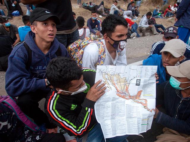 Honduran migrants show their route on a map of Mexico and Central America to reporters, as they sit near a police roadblock at a highway in Vado Hondo, Guatemala, Jan. 17, 2021. (AP Photo/Sandra Sebastian)