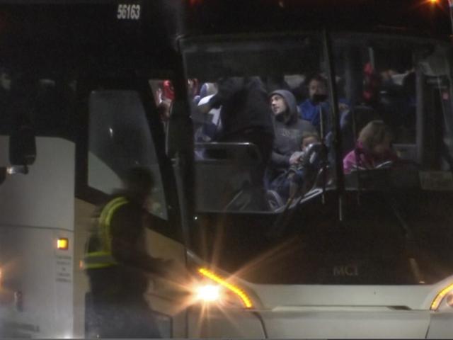 Migrants board a bus as they arrived on a plane from San Antonio at Chicago Rockford International Airport on Jan. 1, 2024 in Rockford, Ill. (WTVO NewsNation via AP)