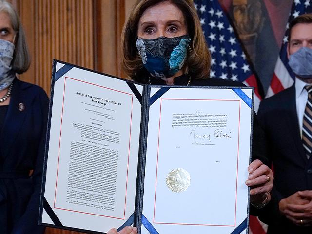House Speaker Nancy Pelosi (D-CA) displays the article of impeachment that she signed against President Donald Trump, Wednesday, Jan. 13, 2021. (AP Photo/Alex Brandon)