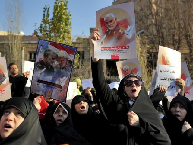 Protesters chant slogans while holding up posters of Gen. Qassem Soleimani during a demonstration in front of the British Embassy in Tehran, Iran, Sunday, Jan. 12, 2020. (AP Photo/Ebrahim Noroozi)
