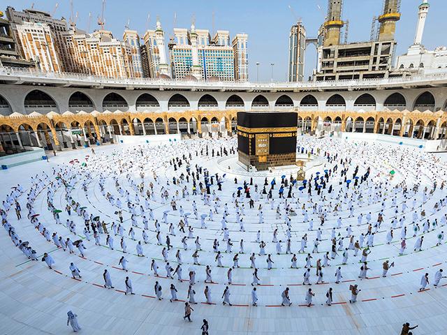 Pilgrims walk around the Kabba at the Grand Mosque, in the Muslim holy city of Mecca, Saudi Arabia, Friday, July 31, 2020.  (Saudi Ministry of Media via AP)