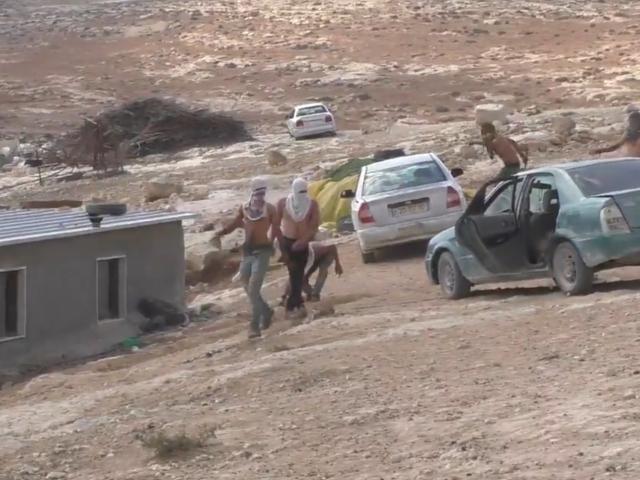 Masked attackers throw rocks at Palestinian homes and cars in the West Bank village of al-Mufaqara. Sept. 28, 2021. Photo Credit: Screenshot of Twitter footage posed by the Israeli rights group B'Tselem.