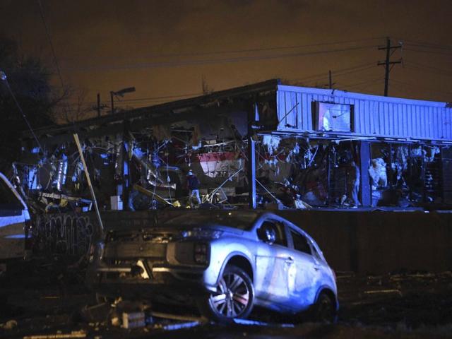 People survey the damage to a building in East Nashville after a tornado hit the city in the early morning hours of Tuesday, March 3, 2020. (Courtney Pedroza/The Tennessean via AP)
