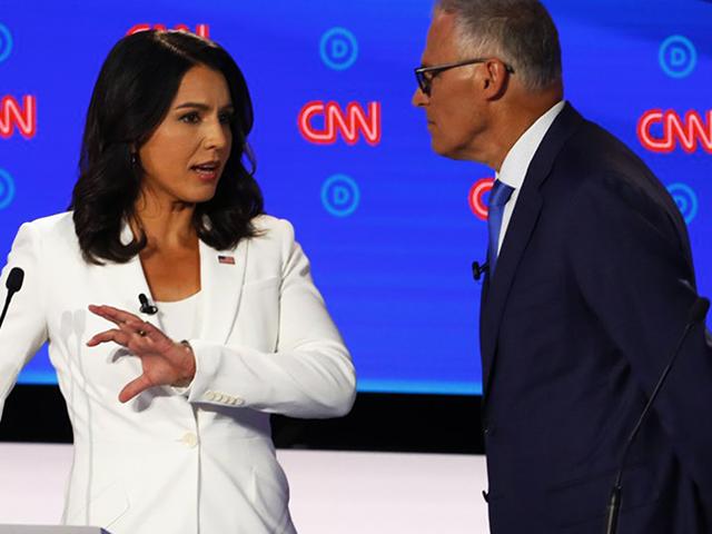 Rep. Tulsi Gabbard, D-Hawaii, and Washington Gov. Jay Inslee chat during a break in the second of two Democratic presidential primary debates hosted by CNN Wednesday, July 31, 2019, in the Fox Theatre in Detroit. (AP Photo/Paul Sancya)