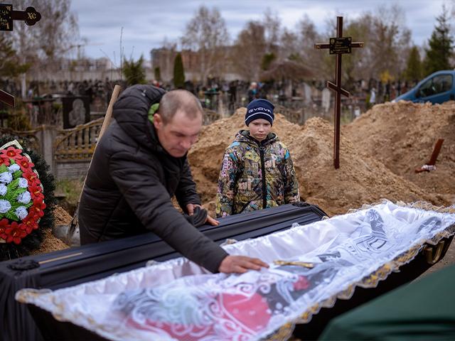 Ivan Drahun and son Vova, 10, mourn their wife and mother Maryna during her funeral in Bucha, on the outskirts of Kyiv, Ukraine, April 20, 2022. Vova&#039;s mother died while they sheltered in a cold basement (AP Photo/Emilio Morenatti)