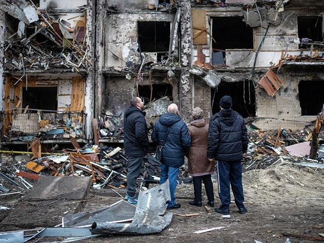 People look at the damage following a rocket attack the city of Kyiv, Ukraine, Friday, Feb. 25, 2022. (AP Photo/Emilio Morenatti)