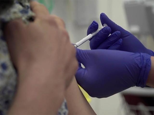 A person being injected as part of the first human trials in the UK to test a potential coronavirus vaccine, at Oxford University, England, April 23, 2020. The first vaccine trial for COVID-19 Coronavirus began Thursday. (Oxford University Pool via AP)