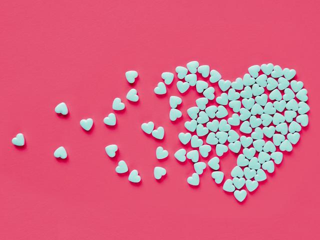 White candy hearts on pink background