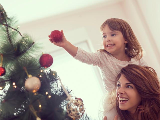Mom and daughter decorating the Christmas tree
