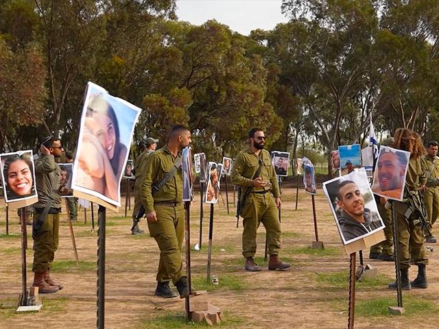 Israeli soldiers walk among photos of people slain and taken captive at the Nova Music Festival. Photo Credit: CBN News.