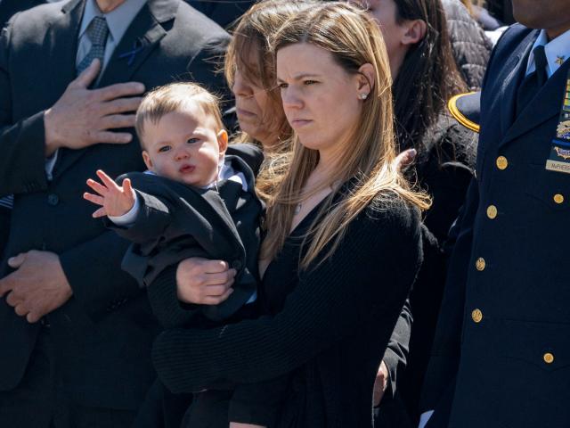Jonathan Diller's wife Stephanie Diller and her son watch the casket during a funeral service for the NYPD officer at Saint Rose of Lima R.C Church in Massapequa Park, NY, on March 30, 2024. AP Photo/Jeenah Moon)