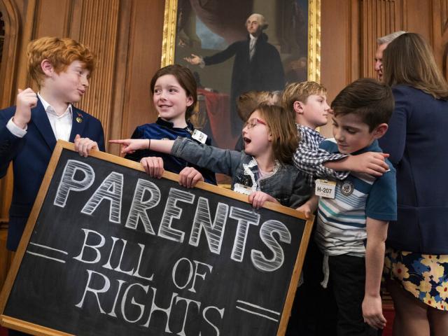 Children play with a chalkboard sign as Speaker of the House Kevin McCarthy, right, speaks with a parent after an event about proposed legislation dubbed the "Parents Bill of Rights," March 1, 2023, on Capitol Hill. (AP Photo/Jacquelyn Martin)