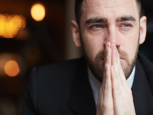 man praying with eyes open and distracted in thought