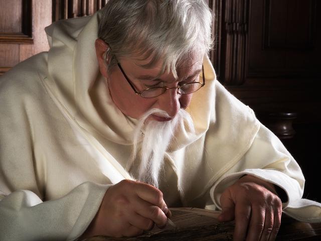 monk writing with a quill pen