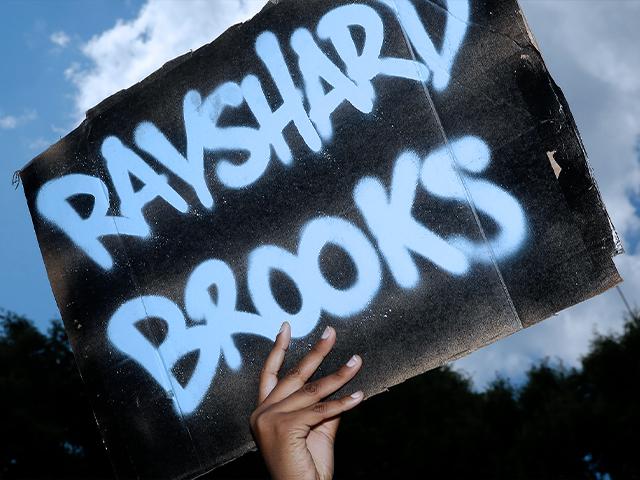 A protester holds up a sign near the Wendy&#039;s restaurant where Rayshard Brooks was shot and killed by police Friday evening following a struggle in the restaurant&#039;s drive-thru line in Atlanta. (AP Photo/Brynn Anderson)