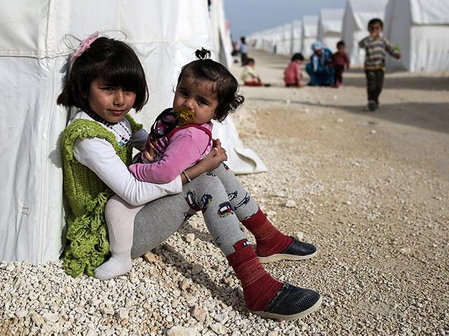 Syrian refugee children who fled violence in Syrian city of Ain al-Arab, known also as Kobani, seen outside their tents in a camp in the border town of Suruc, Turkey, in 2015. (AP Photo)