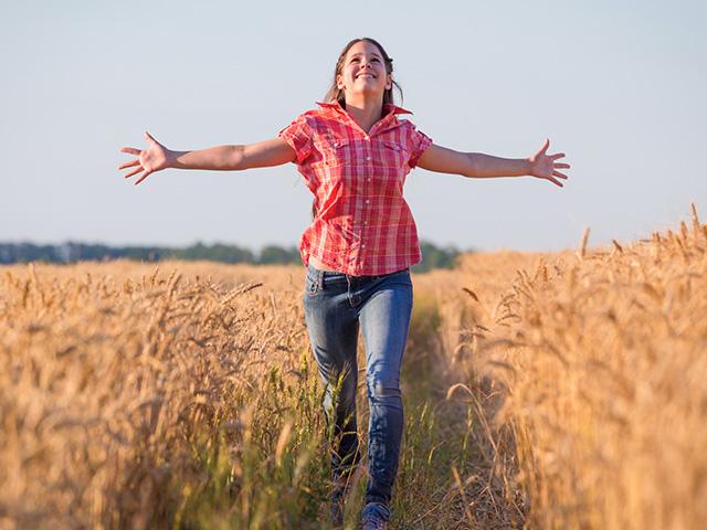 woman running in a wheat field