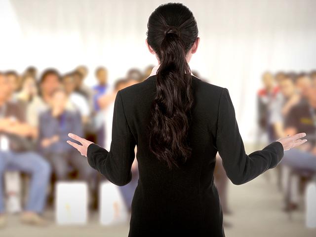 female speaker to crowd at a conference