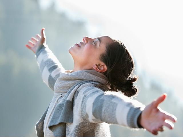 woman praising God with arms wide open