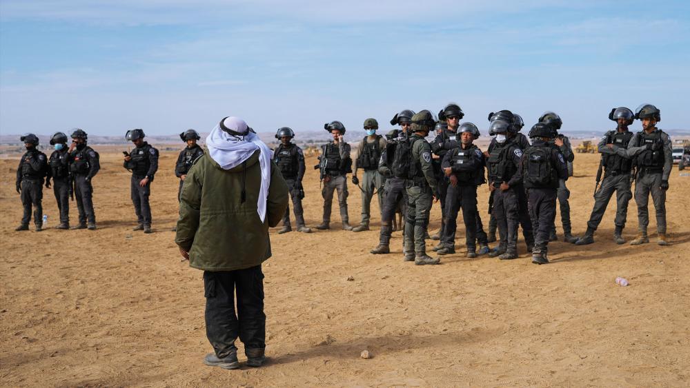 Israeli security forces stand guard as Bedouins protest against tree-planting by the Jewish National Fund on disputed land in the Negev desert. (AP Photo/Mahmoud Illean)
