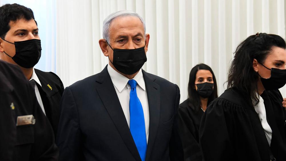 Israeli Prime Minister Benjamin Netanyahu stands at a hearing at the district court in Jerusalem, Monday, Feb. 8, 2021. (AP Photo/Reuven Castro, Pool)