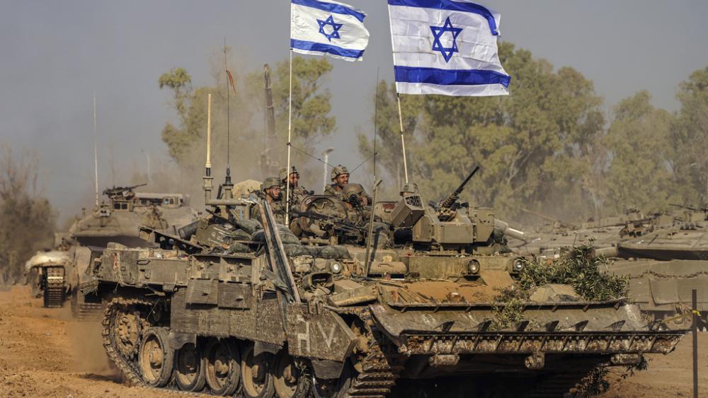 Israeli army vehicles arrive to an staging area after combat in the Gaza Strip in southern Israel, Dec. 30, 2023. (AP Photo/Tsafrir Abayov)