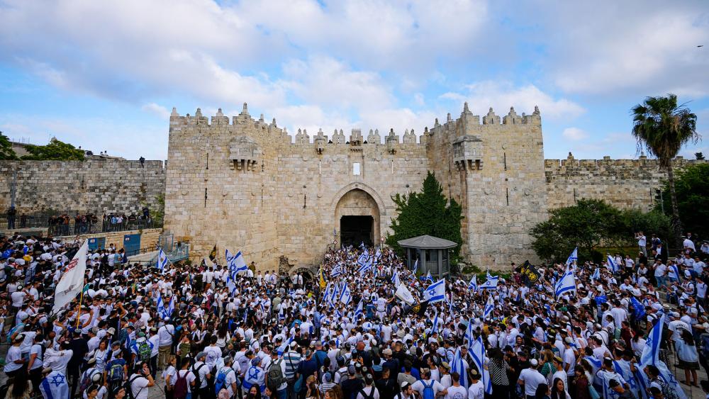 Israelis wave national flags during a march marking Jerusalem Day in front of the Damascus Gate of Jerusalem&#039;s Old City, Thursday, May 18, 2023. (AP Photo/Ohad Zwigenberg)