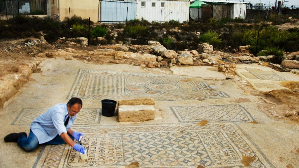 A conservationist from the Israeli Antiquities Authority (IAA) works on the “Jesus” mosaic found near a prison in Megiddo. Photo Credit: IAA