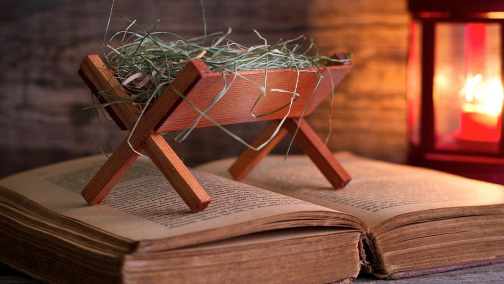 tiny manger sitting on top of a Bible