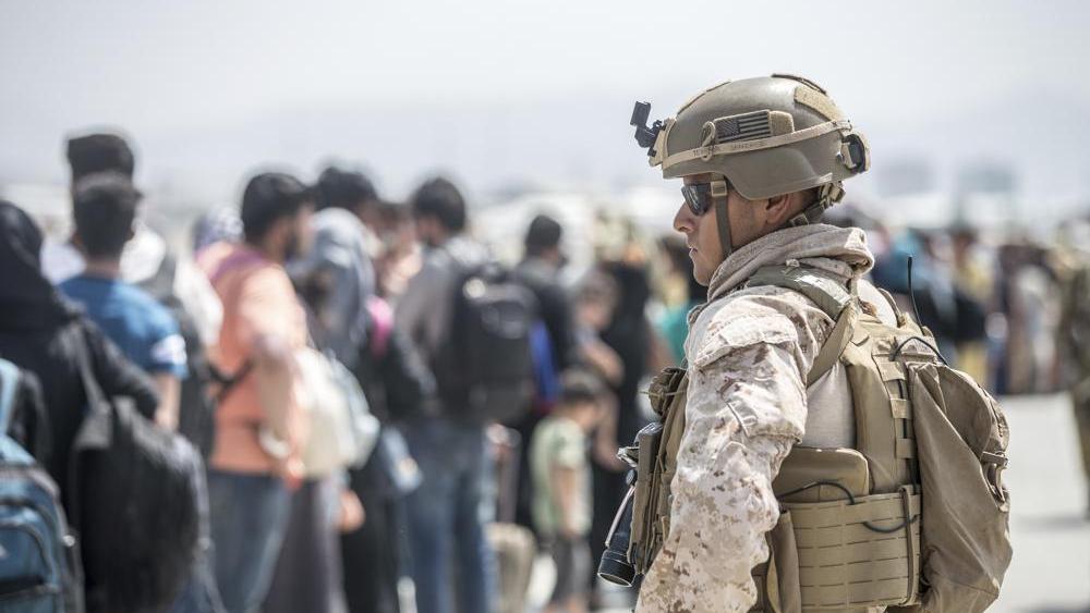 A Marine with Special Purpose Marine Air-Ground Task Force-Crisis Response-Central Command provides assistance during an evacuation at Kabul Airport (Sgt. Samuel Ruiz/U.S. Marine Corps via AP)