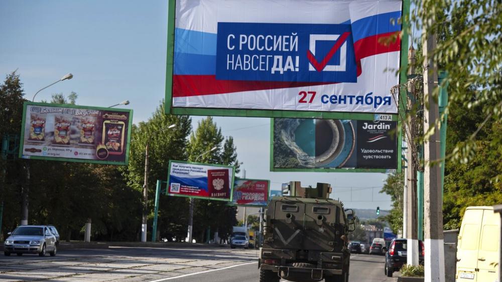  military vehicle drives along a street with a billboard that reads: &quot;With Russia forever, September 27&quot;, prior to a referendum in Luhansk, Luhansk People&#039;s Republic. (AP Photo)