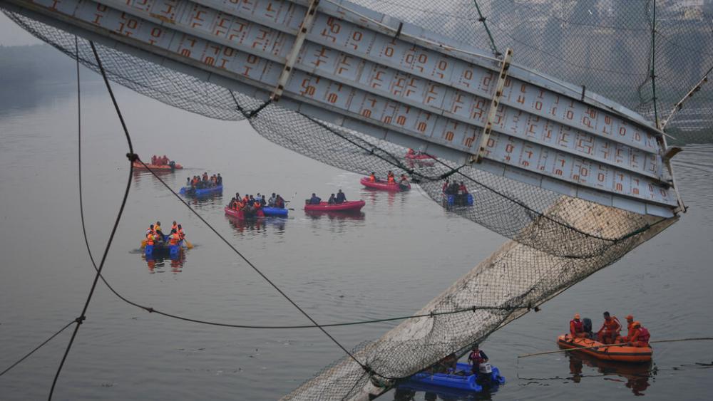 Rescuers on boats search in the Machchu river next to a cable suspension bridge that collapsed in Morbi town of western state Gujarat, India, Monday, Oct. 31, 2022.  (AP Photo/Ajit Solanki)