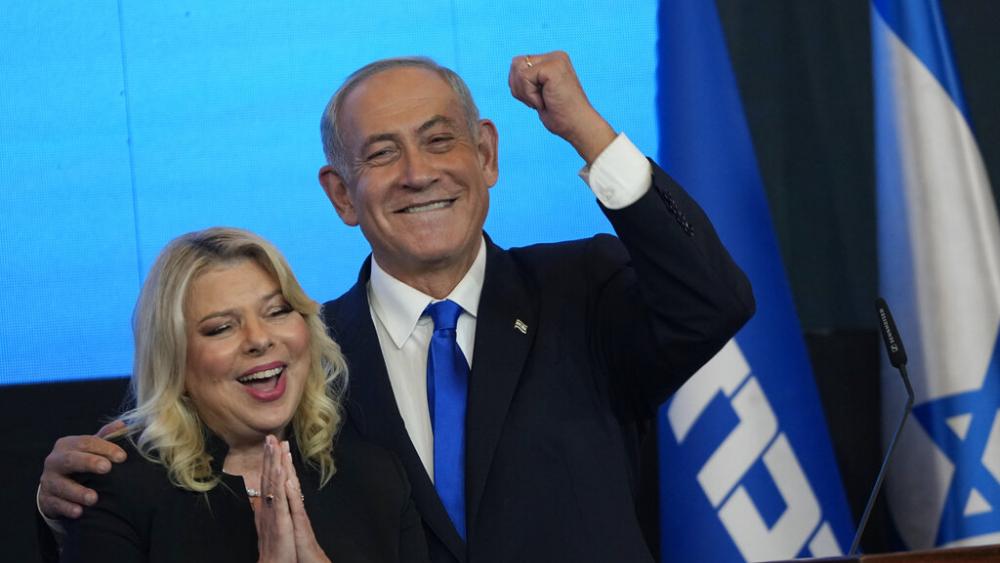 Former Israeli Prime Minister and the head of Likud party, Benjamin Netanyahu and his wife Sara gesture after first exit poll results for the Israeli Parliamentary election. (AP Photo/Tsafrir Abayov)