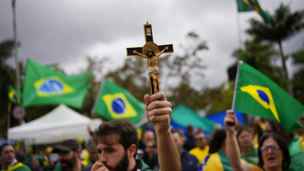A supporter of Brazilian President Jair Bolsonaro holds a crucifix during a protest against his defeat in the country&#039;s presidential runoff. (AP Photo/Matias Delacroix)