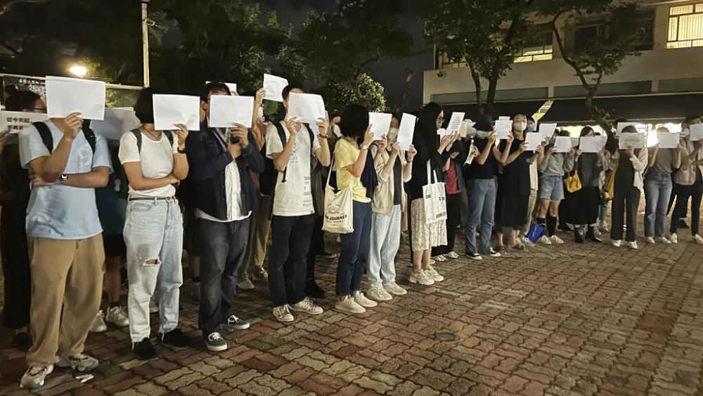 Protesters hold up blank white papers during a commemoration for victims of a recent Urumqi deadly fire at the Chinese University of Hong Kong in Hong Kong, Monday, Nov. 28, 2022. (AP Photo/Kanis Leung) 